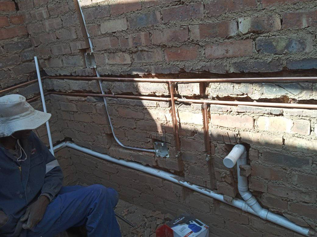 Commercial plumbing installation with copper and PVC pipes